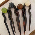 Colette Bonbon tortoise hair pin with glass bead in a low bun