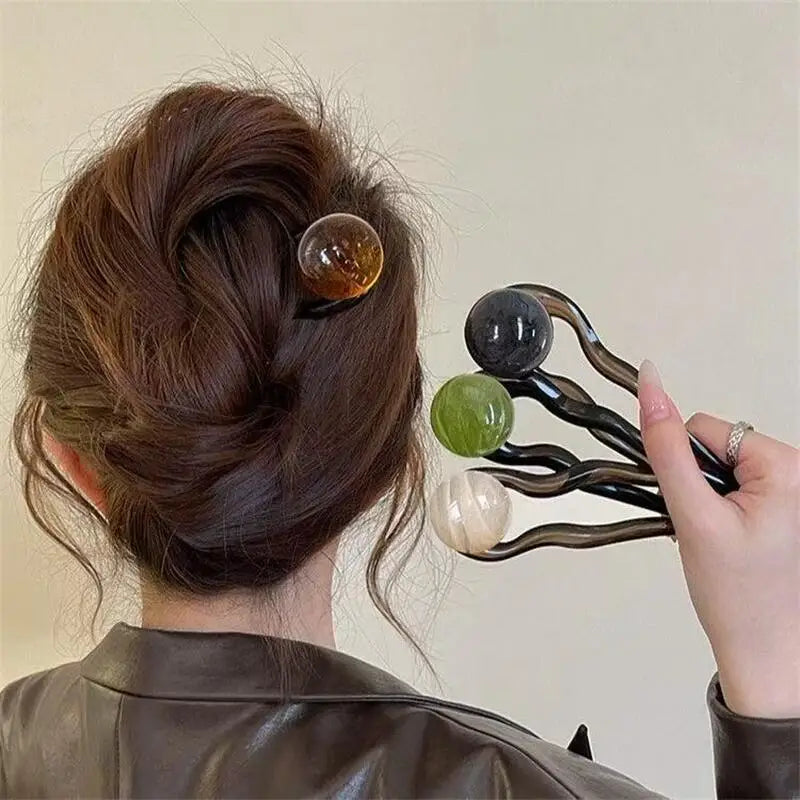 Colette Bonbon tortoise hair pin with glass bead in a low bun