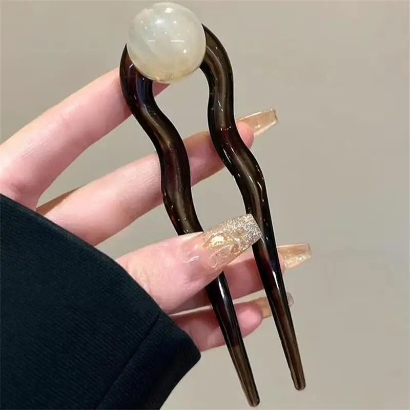 Colette Bonbon tortoise hair pin with glass bead in a low bun