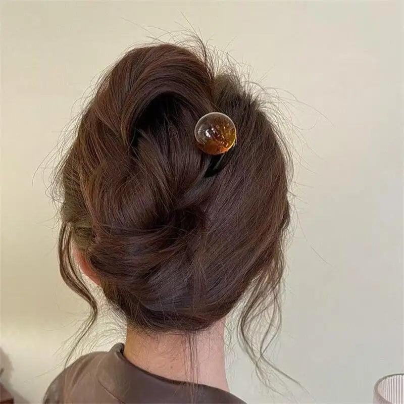 Colette Bonbon tortoise hair pin with glass bead in a low bun