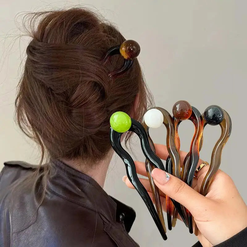Colette Bonbon tortoise hair pin with glass bead in a low bun