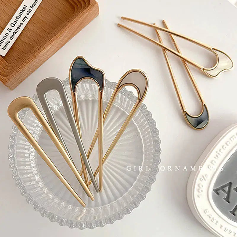 Colette Nacre shell-inlay gold French hair pin in a chignon