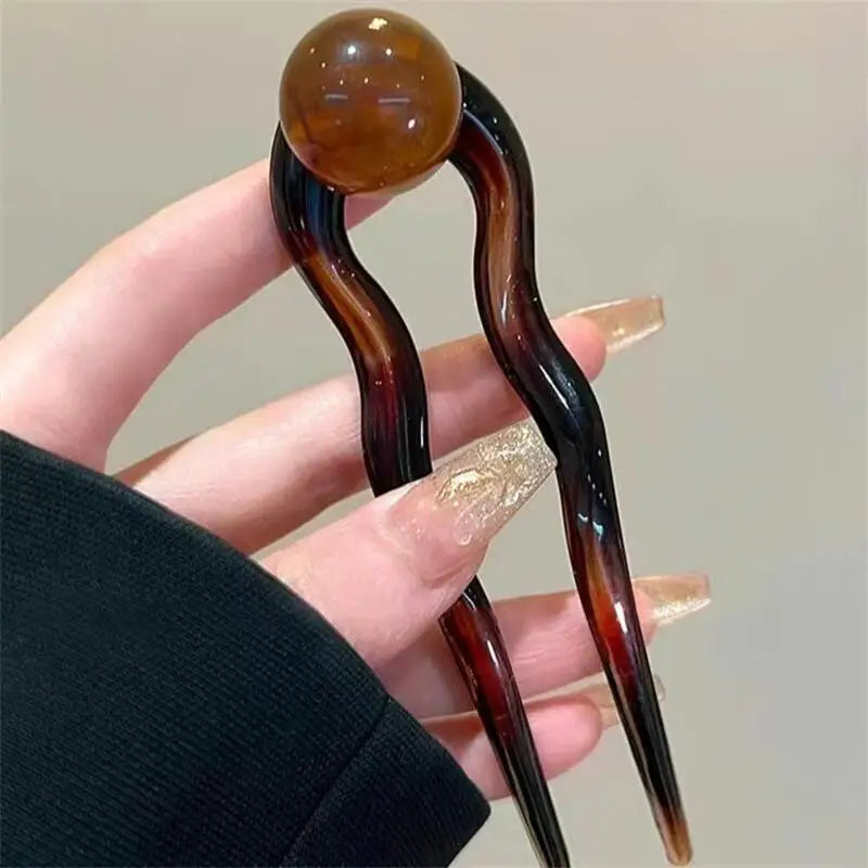 Colette Bonbon tortoise hair pin with glass bead in a low bun