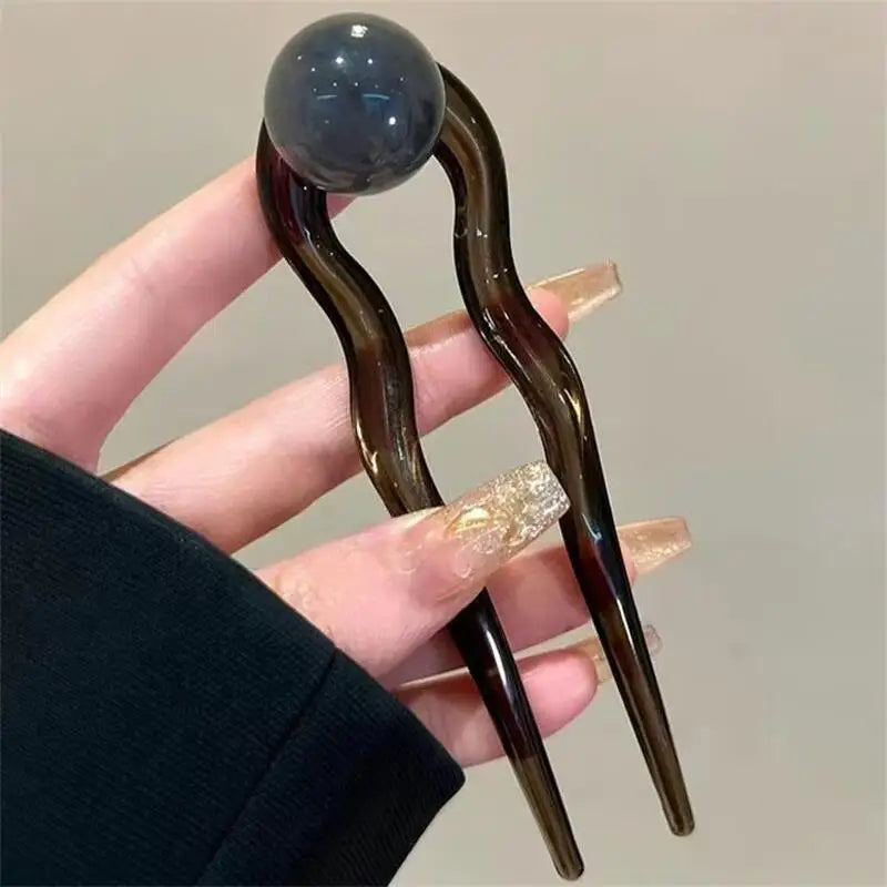 Colette Bonbon tortoise hair pin with glass bead in a low bun
