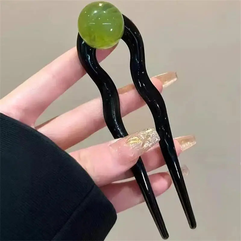 Colette Bonbon tortoise hair pin with glass bead in a low bun